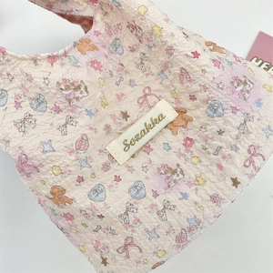 Nahaufnahme der rosa Seersucker-Tasche mit gesteppten Comic-Hund und Schleifen