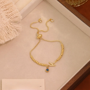 Dettaglio del bracciale Evil Eye regolabile dorato con ciondolo lettera K su vassoio