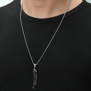 Close-up of a men's vintage silver fishbone pendant necklace worn on a black shirt