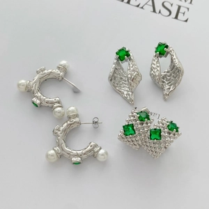Modern geometric C-shaped earrings set with green stones and pearls in silver finish