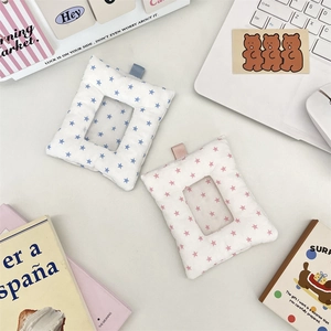 Detail of plush fabric card holder with star pattern and clear window on desk