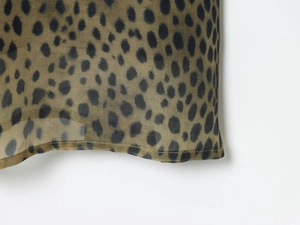 Nahaufnahme eines Kleides mit Leopardenmuster, olivgrünem Chiffon und Saumverarbeitung