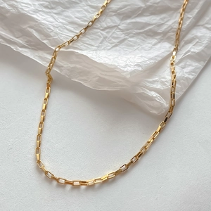 Minimalist 14K gold plated stainless steel box chain necklace on white textured background
