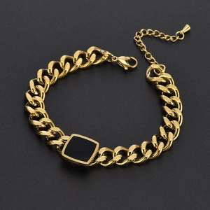 Polished gold Cuban link bracelet with square black shell inlay on a dark background