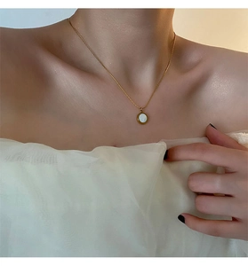 Elegant 18K gold plated titanium necklace featuring a white shell pendant on a model
