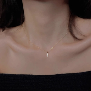 Elegant 14k gold plated bar necklace with sparkling diamonds worn by a model