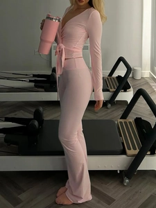 Ensemble de yoga rose avec haut à manches longues col en V et pantalon évasé taille haute