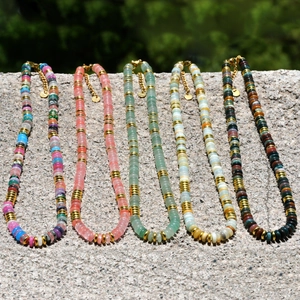 Détail de cinq colliers en perles de pierre naturelle colorées avec intercalaires dorés