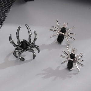 Detailed macro shot of gothic spider ring and earrings with black gems and silver metal