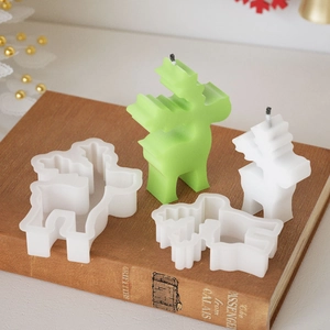 Detail view of silicone reindeer candle molds and finished wax figures on vintage books