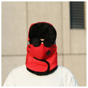 Détail de la chapka rouge avec fourrure noire, masque à valve respiratoire et lunettes