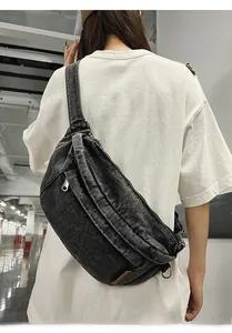 Detail of vintage black denim crossbody bag with multiple zippers and wide strap