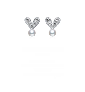 Macro shot of 925 sterling silver heart earrings with pavé crystals and white pearls