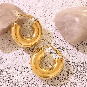 Chunky gold U-shaped geometric hoop earrings in polished finish on a stone background