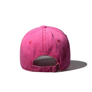Detail view of the adjustable metal buckle and washed fabric texture on a pink baseball cap