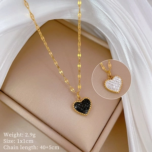 Detail of gold heart pendant with beaded edge showing black and white stone options