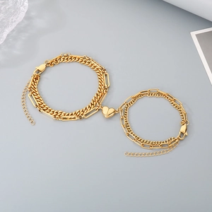 Detail of gold layered Cuban and rectangular chains with heart magnetic clasp
