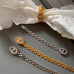 Elegant gold and silver chain bracelet with zircon pavé setting on a grey background