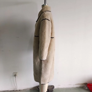 Vista laterale del cappotto in lana di agnello beige con collo alto e profili a contrasto