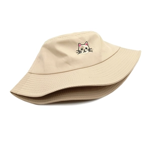 Detailed close-up of cute cat embroidery on a beige cotton bucket hat with stitching