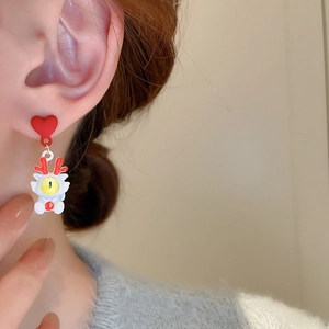 Détail de boucles d'oreilles cœur rouge avec pendentif dessin animé sur un mannequin