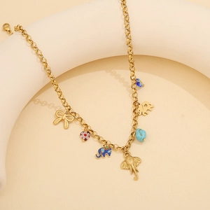 Golden necklace with elephant charms, colorful beads and bow on a soft beige background