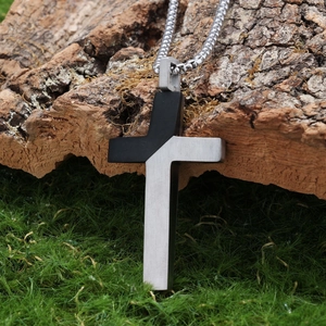 Retro two-tone stainless steel cross pendant necklace with brushed metal finish on tree bark