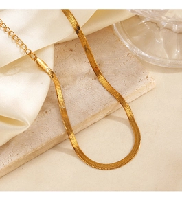 Detailed view of a golden snake chain anklet displayed on a textured stone surface
