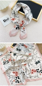 Detail of silk square scarf showing pink thorn vine and floral patterns on white base
