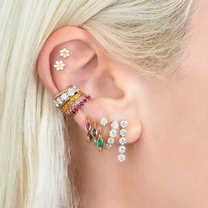 Gros plan de boucles d'oreilles créoles dorées ornées de zircons ovales multicolores