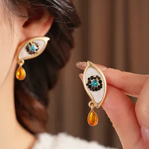Vintage eye-shaped gold earrings with turquoise gem and orange water drop pendant