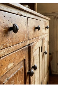 Close-up of vintage cast iron drawer handle with rustic texture on old wood cabinet