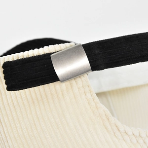 Close-up of corduroy baseball cap with adjustable metal buckle and strap detailing
