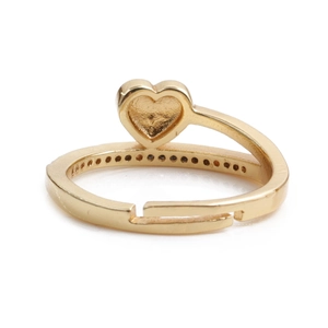 Détail d'une bague coeur dorée réglable avec des petits zircons incrustés sur le côté