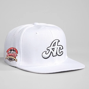Detailed view of the 3D AC embroidery and side sports patch on this white baseball cap