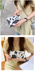 Lifestyle view of a stylish cow print PU leather wallet with a secure zipper closure