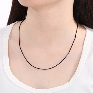 Close-up of a minimalist black cord snake chain necklace worn on the neck