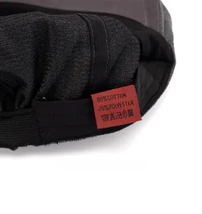 Macro detail of the fabric care label inside the herringbone newsboy cap for men