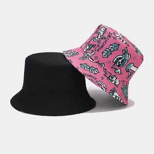 Close-up of reversible bucket hat set featuring black cotton and pink graffiti print