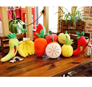 Close-up of soft plush vegetable and fruit toys on a wooden table with warm lighting