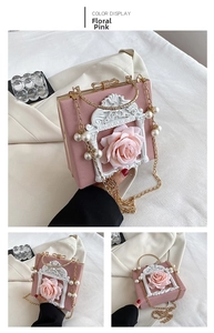Detail of floral pink baroque embossed handbag with a golden bow clasp and pearl chain