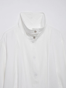 Detail of white linen bomber jacket showing the stand collar and silver metal snap buttons