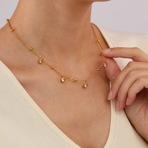 Close-up of minimalist gold plated stainless steel necklace with clear zircon stones