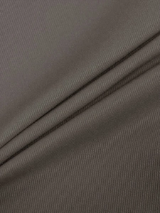Dettaglio macro della trama del tessuto twill marrone scuro sui pantaloni cargo