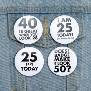 Close-up of four round humorous pins featuring creative text on a blue denim jacket pocket