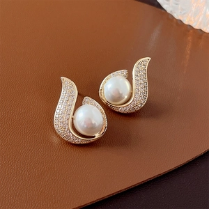Elegant gold fishtail earrings with white pearls and sparkling cubic zirconia stones