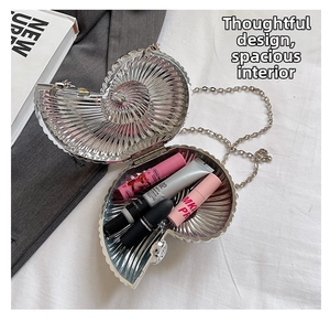Silver snail-shaped evening bag interior view with metal chain and cosmetics