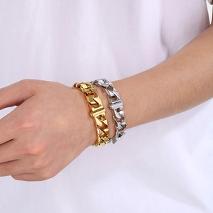 Detail of 13mm gold and silver Cuban link bracelets on wrist for men fashion