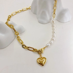 Detail of 14K gold plated chain necklace with freshwater pearls and a heart pendant
