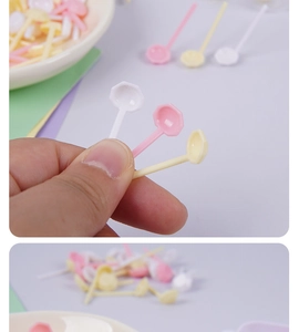 Close-up of mini plastic hexagonal spoons in pink, white, and yellow for cosmetics